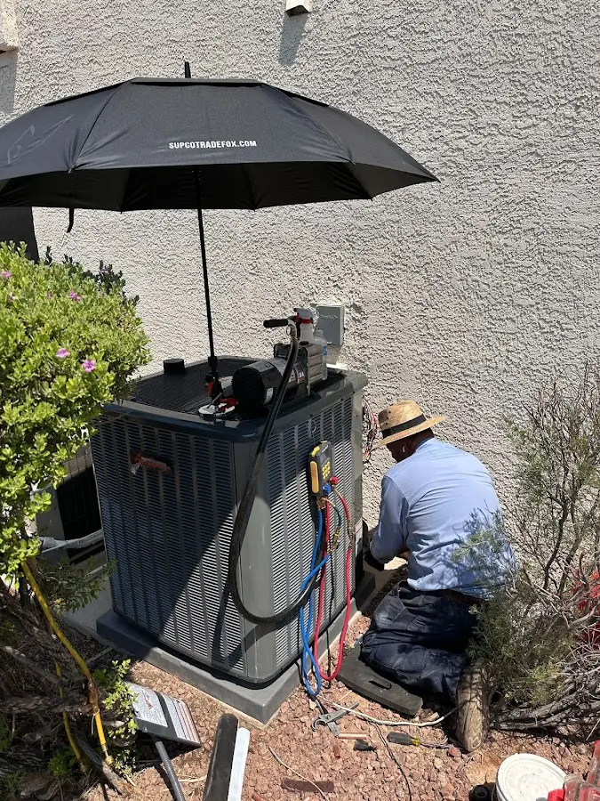 HVAC technician performing outdoor AC maintenance in Kenai
